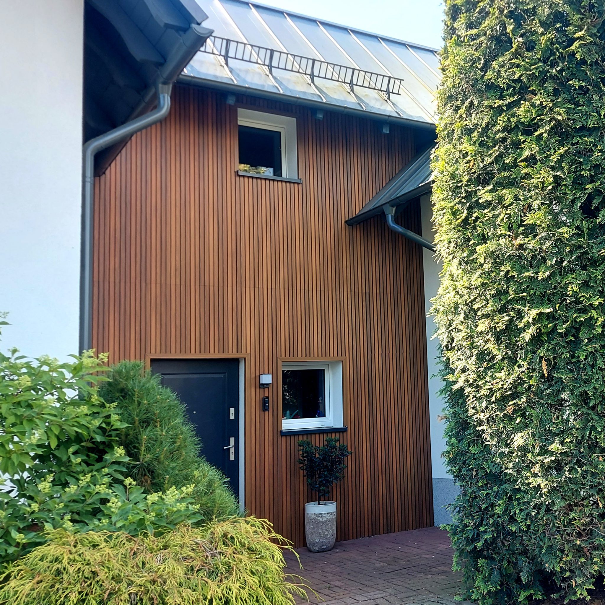 Modern facade with composite slatted cladding boards Premium Amber